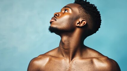 A man with a short beard and a shaved head looks up at the sky - Powered by Adobe