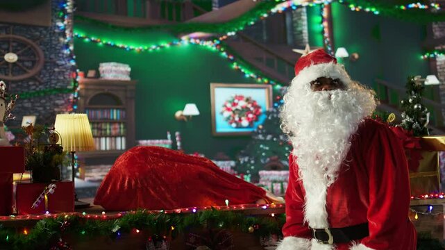 African american saint Nick preparing his bag full of gifts in wrapping paper, delivering presents to wishful children around the world. Father Christmas spreading the x mas spirit. Camera B.
