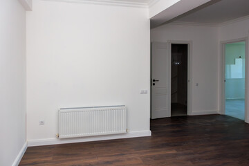 A white room with a radiator and a door