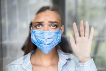 Social Distancing. Depressed Girl Wearing Face Mask Looking Out Of Window Standing At Home During...