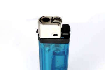 A close-up of a blue disposable lighter. The lighter is made of translucent blue plastic and has a silver metal top. The lighter is partially filled with lighter fluid.