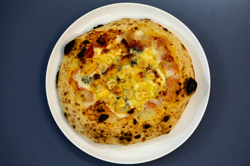 Traditional rustic pizza made with four cheeses, garlic and oil and pear with gorgonzola