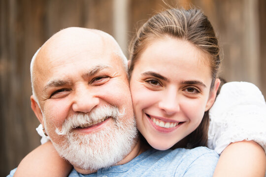 Senior old man and daughter hug and kiss. Lady with sugar daddy, close up portrait. Senior grandad and young woman in love. Daughter and father kiss in love. Grandad and granddaughter. Parents love.