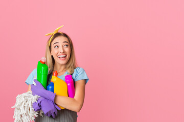 Fototapeta premium Housewife holds in her hands cleaning supplies and look at empty space