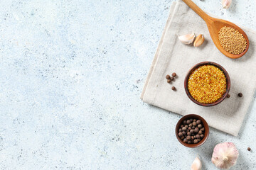 Bowl of Dijon mustard with peppercorn and garlic on white background