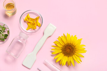 Professional laboratory tools with sunflower, oil and sprouts on pink background