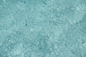 Ripple Water in swimming pool with sun reflection. Wavy water background.