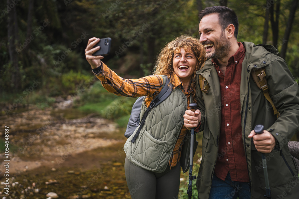 Wall mural husband and wife hiker take a self portrait or video call on hiking