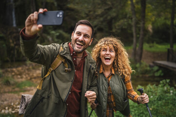 Fototapeta premium husband and wife hiker take a self portrait or video call on hiking