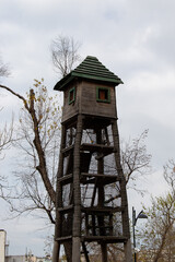 A wooden structure resembling a watchtower. A tall wooden tower with a wooden hipped roof