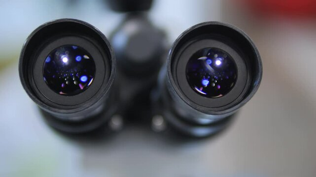 A detailed closeup view of microscope lenses showcasing various reflections and light