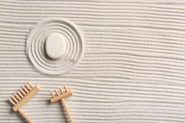 Stone and small rakes on light sand with lines. Zen concept