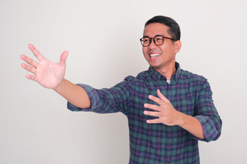 A man looks far ahead trying to reach something with a happy facial expression
