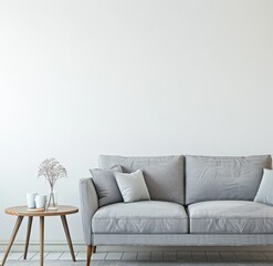 Naklejka premium A minimalist living room with a gray sofa and a wooden coffee table There is a vase with dried flowers on the table and a white wall in the background