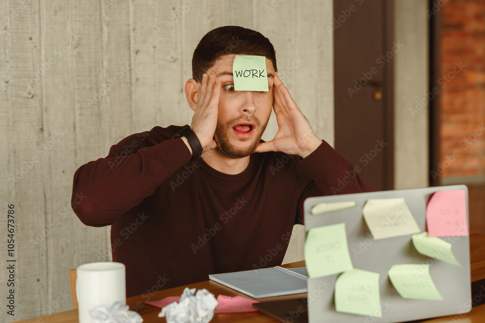 Poster too much work. shocked man touching face having sticky notes everywhere sitting at laptop in modern 
