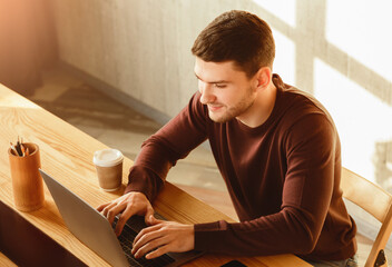 Freelancer Copywriter Man Working At Laptop Computer Writing Article In Modern Office. High-Angle...