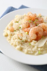 Delicious risotto with shrimps and cheese on white table, closeup