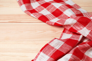 Obraz premium Crumpled tablecloth with checkered pattern on light wooden table, space for text