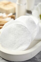 Clean cotton pads on grey table, closeup