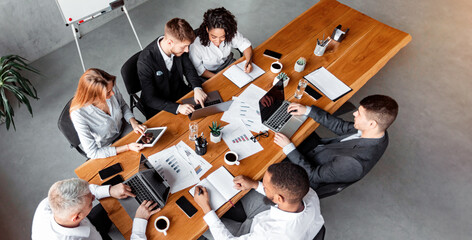 Business Meeting. Diverse Colleagues Talking Sitting With Gadgets During Corporate Event In Office. High-Angle