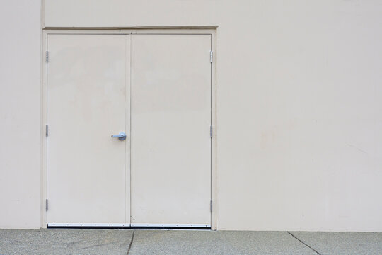 An abstract image of steel exterior double doors on a commercial industrial building. 