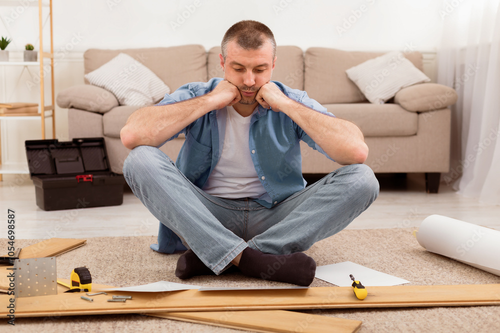 Poster Furniture Assembly Trouble. Sad Man Sitting Near Disassembled Shelf Having Problems Installing Self-Assembly Kit At Home.