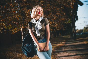 Photo of pretty young blonde woman walk college hold book wondered wear khaki clothes tied...