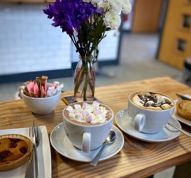 Quaint coffee and cheese cafe in Ballater, Cambus O&rsquo;May, Aberdeenshire, Scotland. Picture features several hot chocolates and baked goods.