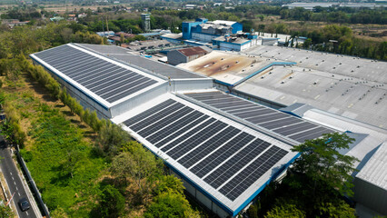 A large factory with solar panels installed across its expansive rooftop, harnessing sunlight to...