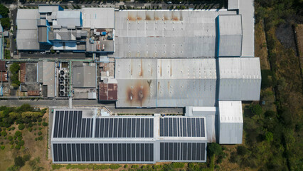 A large factory with solar panels installed across its expansive rooftop, harnessing sunlight to generate sustainable energy.