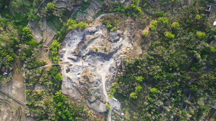 busy mining activity and the unspoiled natural beauty of the surrounding area. Amidst a stretch of towering green trees, mine workers work hard, creating a unique blend of humans and nature.