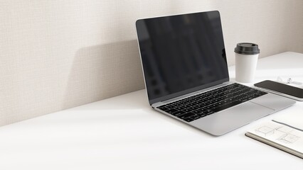 Desktop of modern white desk with laptop computer, smartphone, earphone, notebook, eyeglasses and coffee cup in sunlight from window on beige wall for home office working, product background 3D