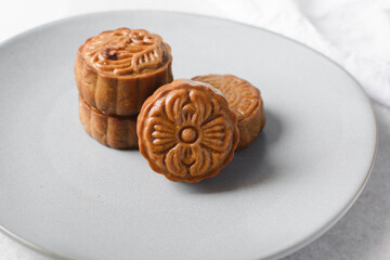 Overhead view of homemade mooncakes, top view of baked mooncakes on grey plate, process of making mooncakes for Lunar New Year and mid autumn festival