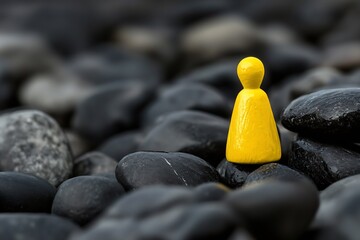 Unique Yellow Figurine on Black Pebbles Symbolizing Individuality Concept : Generative AI