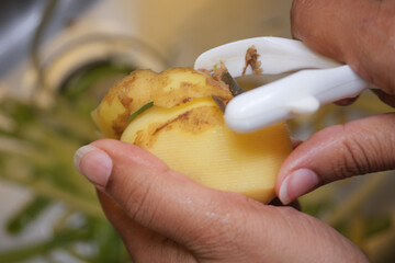 Peeling a Fresh, Delicious Potato in the Kitchen for Cooking Amazing Meals and Recipes