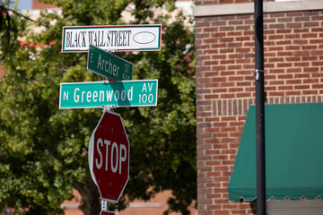 Tulsa, Oklahoma, USA - June 25, 2023: Afternoon sun shines on a sign of the historic Greenwood District Black Wall Street, site of the 1921 Tulsa Race Massacre.