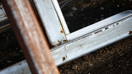 Rusty metal plate with shadow on white wall. Shallow depth of field.