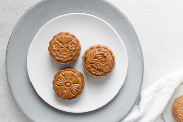 Overhead view of homemade mooncakes, top view of baked mooncakes on white plate, process of making mooncakes for Lunar New Year and mid autumn festival