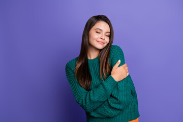 Fototapeta premium Photo of pretty young girl closed eyes hug shoulders wear pullover isolated on purple color background