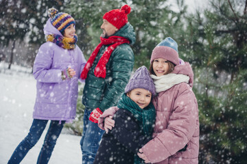 Photo of cheerful positive little child wife husband dressed coats embracing together smiling outdoors urban forest park