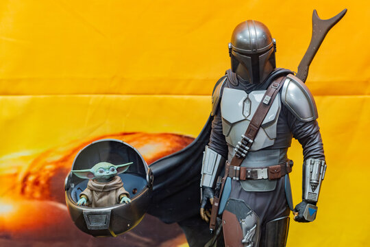 8th Comic Con Convention In GUAYAQUIL, ECUADOR - AUG 06, 2023 -Mandalorian and Grogu figurines against vibrant orange background, inspired by the Star Wars series. Perfect for sci-fi and collectible