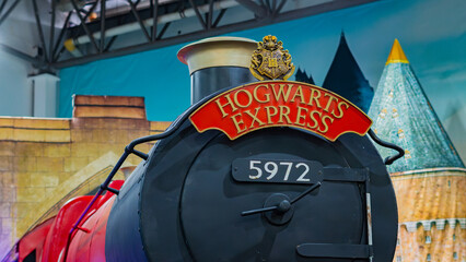 Naklejka premium 8th Comic Con Convention In GUAYAQUIL, ECUADOR - AUG 06, 2023 - Iconic Hogwarts Express train with steam, displaying the famous crest and sign, perfect for fantasy and magic themes.