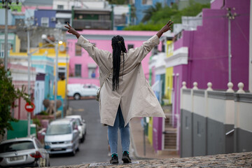 Happy woman seen in Cape Town with blurred background of colorful houses