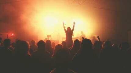Fototapeta premium Silhouette of concert crowd in front of bright stage lights and smoke.