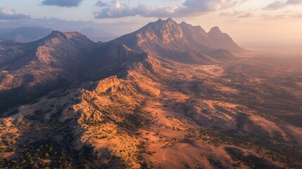 Obraz premium Aerial view of the mystical landscape of Socotra Island during the golden hour, with warm light illuminating the unique terrain. No people included.