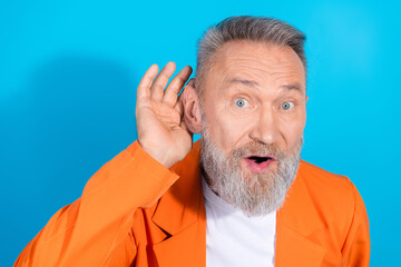 Portrait of modern stylish aged man eavesdrop stare wear orange costume isolated on blue color...