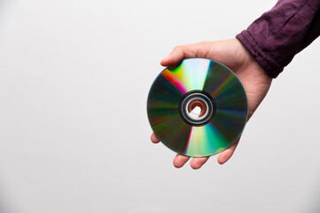cd disk in female outstretched hand on white background, close-up. retro equipment for data recording and storage of materials