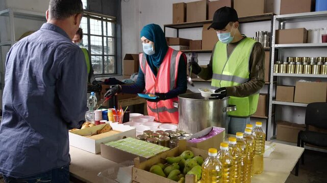 Free hot food. Multiracial group of people working on humanitarian aid project. Teamwork in homeless shelter