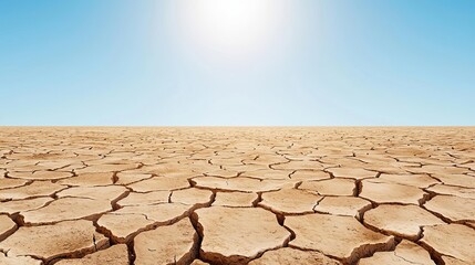 A vast, dry landscape showcasing cracked earth under a bright blue sky, symbolizing the effects of drought and climate change.
