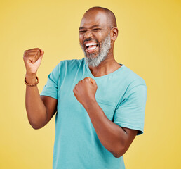 Excited, fist pump and winner with mature black man in studio isolated on yellow background for...
